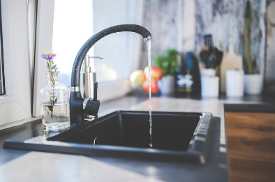 Agua que sale de un grifo abierto en una cocina